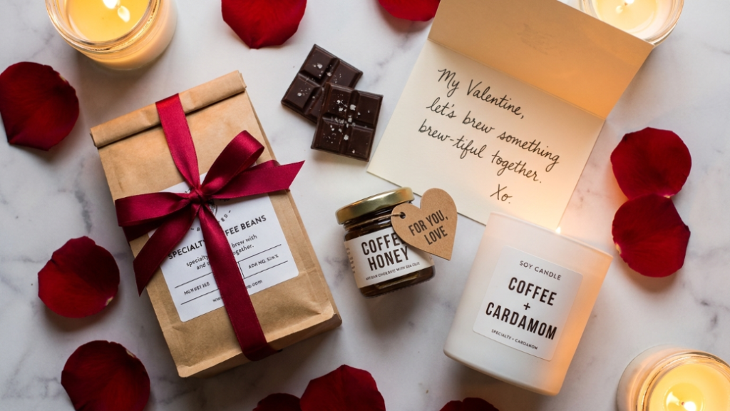 Valentine's Day coffee gifts under 25 pounds showing specialty single origin coffee bag with red ribbon two squares of dark artisan chocolate a small coffee honey jar a coffee scented soy candle and a handwritten love note card as thoughtful affordable romantic coffee gift ideas on white marble with rose petals