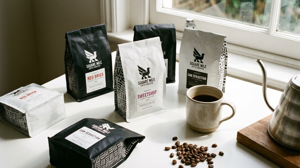 Square Mile Coffee Roasters distinctive minimalist packaging bags on a white surface with Walthamstow roastery in background
