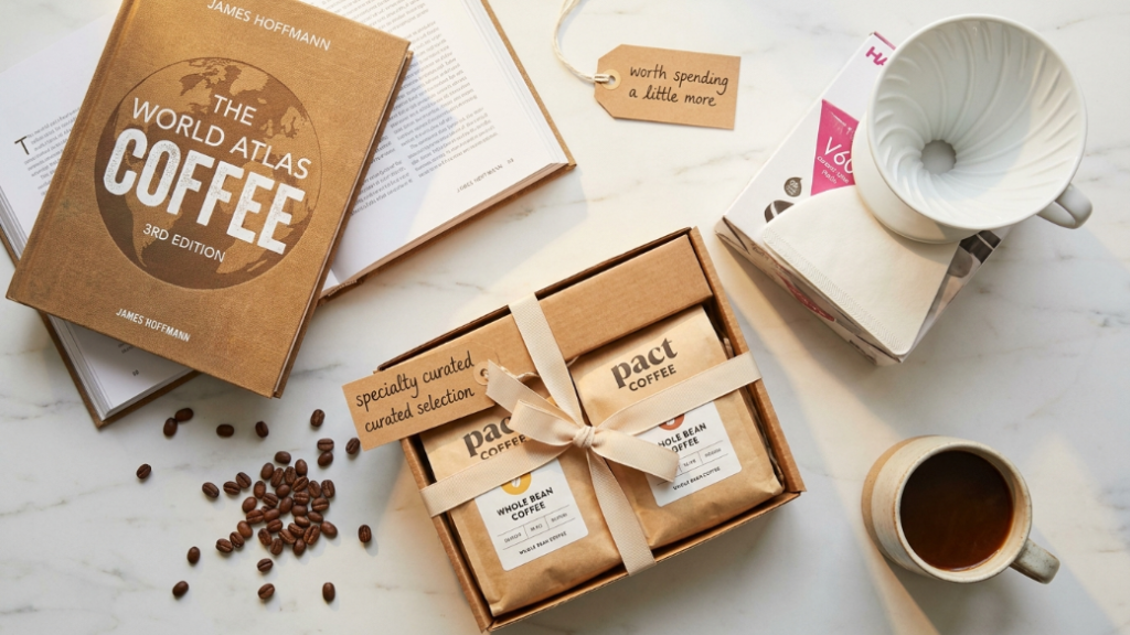 Secret Santa coffee gifts just over £20 and $25 showing Pact Coffee specialty curated selection box with ribbon James Hoffmann World Atlas of Coffee 3rd edition book and Hario V60 ceramic dripper starter kit as gifts worth spending a little more on for Secret Santa