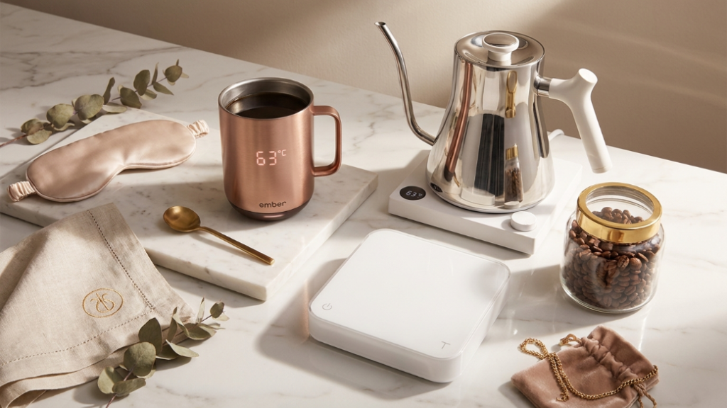 Luxury coffee gifts for her over 100 dollars showing Ember Smart Mug 2 in rose gold with temperature display visible Fellow Stagg EKG gooseneck kettle in polished steel and Acaia Pearl coffee scale in white as luxury women's coffee gifts for the serious home barista or the woman whose coffee always goes cold