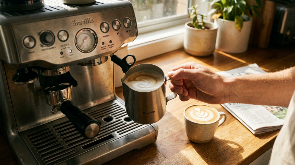 Best milk for coffee Australia 2026 showing milk being steamed for a flat white in a small jug beside a latte art cup on a kitchen bench